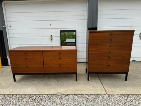 Two wooden dressers in front of a white garage door.
