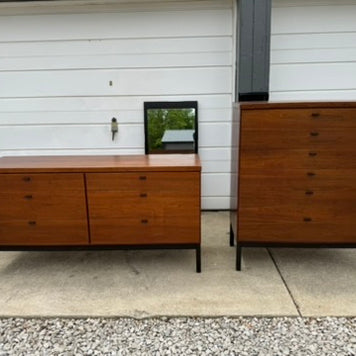 Two wooden dressers in front of a white garage door.