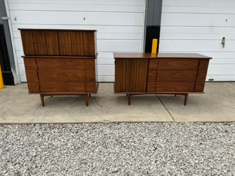 Two wooden dressers on a concrete surface with a white wall in the background