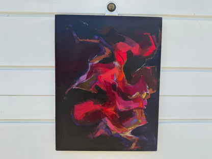 Abstract painting with red and purple tones on a dark background, mounted on a wooden surface.